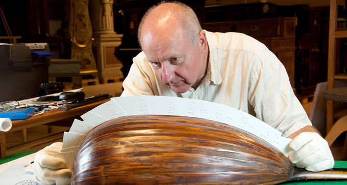 Lars Jönsson undersöker originallutan. Foto: Sofi Sykfont